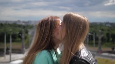 Yakın çekim, iki kız arkadaşım karşılamak, birbirlerine sarılmak ve mutlu bir şekilde konuşmak.