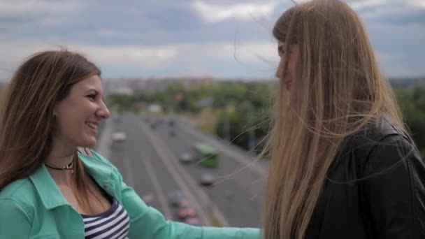 Gros plan, deux jeunes femmes mignonnes et riantes se disent au revoir . — Video