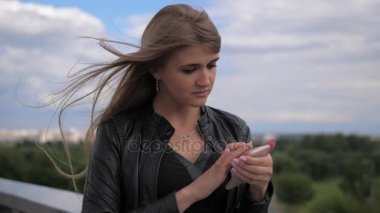 Güzel sarışın dalgın cep telefonu, ekran, sokakta dokunmadan bakıyor