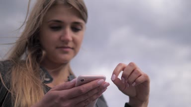 Ekran, portre dokunmadan cep telefonu neşeli sarışın dalgın bakıyor