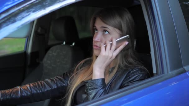 Młoda atrakcyjna kobieta siedzi w zaparkowany samochód i przysięga na telefon — Wideo stockowe