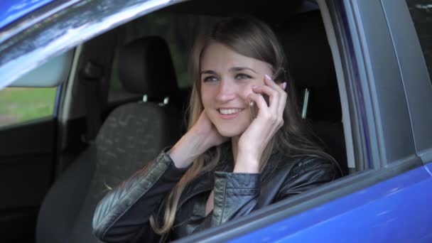 Joven bonita mujer sentada en el coche y divertirse hablando por teléfono — Vídeo de stock