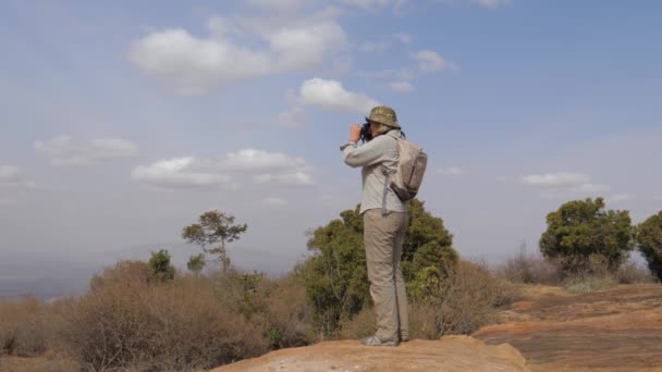 Женщина-турист стоит и фотографирует открытую панораму — стоковое видео