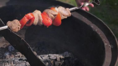 Erkek el closeup yemek pişirmek için ızgara şiş yatıyordu