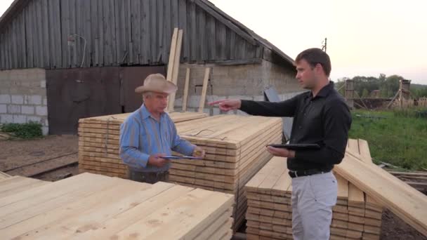 Adult And Young Businessman Check And Count The Packing Of Wooden Boards. — Stock Video