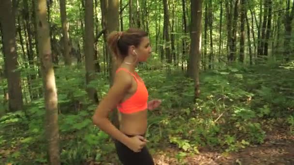 Lovely Woman Running Forest On The Road In Headphones, Side View — стоковое видео