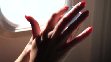 Closeup Womans uçak pencerenin önünde oturan telefon kullanarak ele