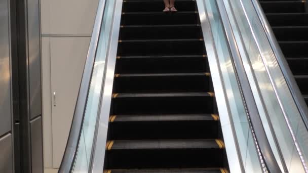 Jolie jeune femme brune descendant l'escalator — Video