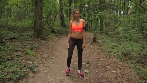 Docela sportovní žena před spuštěním v parku uhněteme a protáhnout svaly — Stock video