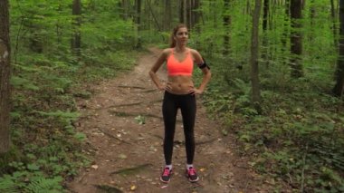 Spor kadın değer sık sık ve yoğun bir orman yolda koşu sonra nefes alır