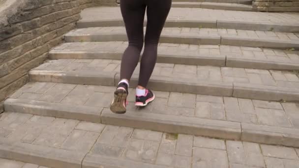 Gros plan sur les jambes féminines athlétiques, montant les escaliers — Video
