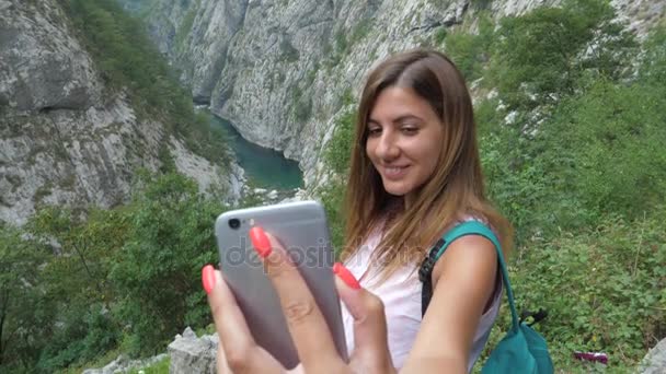女性の旅行者は、スマート フォンの美しい山渓谷の Selfie — ストック動画