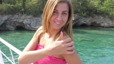 Azure deniz arka plan üzerinde dururken gülümseyen genç kadın portresi yakın çekim