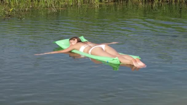 Szép cserzett nő a fehér Bikini, lebeg a folyón, a matrac. 4k