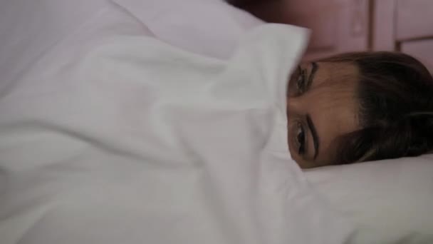 Se réveille au lit belle femme dans le maquillage sourit et retourne à l'autre côté — Video