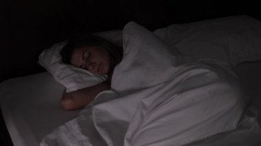 Kadın hızlı bir şekilde ağarma karanlıkta yatakta uyur, ışık uyku ile müdahale