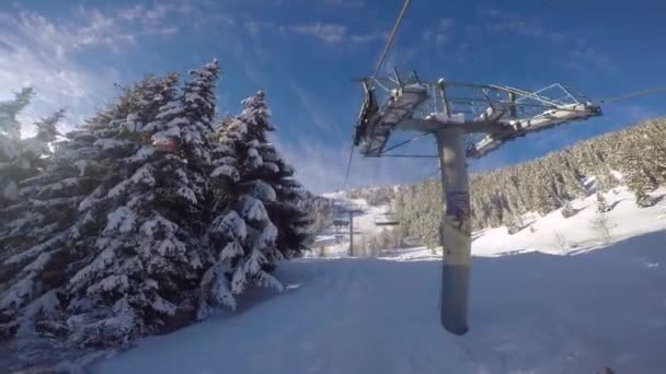 Narciarstwo narciarzy wzniesienia przez wyciągu krzesełkowego wyciągu narciarskiego wzdłuż torów. — Wideo stockowe