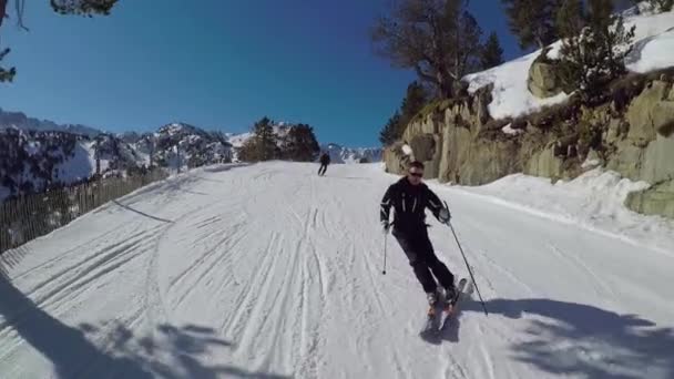 Esquiador rueda por la pista de esquí de invierno tallado en las montañas . — Vídeos de Stock