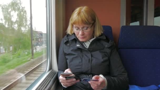 Una mujer monta en el tren de alta velocidad y paga con una tarjeta de crédito por teléfono . — Vídeos de Stock