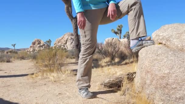运动的女人在牛仔帽把他的脚在石头上, 全景底部 — 图库视频影像