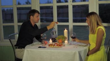 Güzel çift Restoran, adam el-besleme onun kız arkadaşı kanepeler oturur.