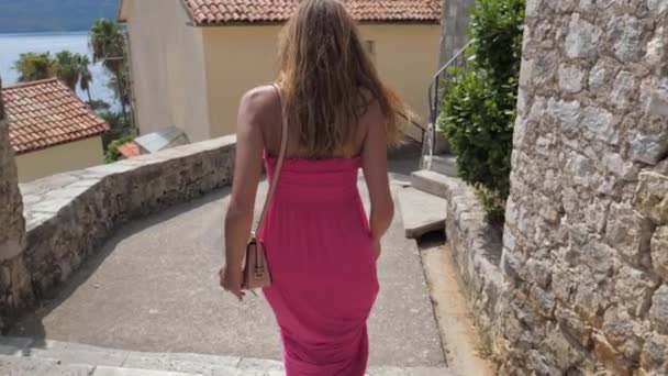 Femme Dans Une Robe Rose Descend Les Escaliers De L'ancienne Ville De Pierre, Vue De L'arrière — Video