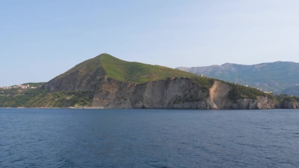 Vista desde el mar en la costa rocosa y montañas verdes en movimiento 4K — Vídeo de stock
