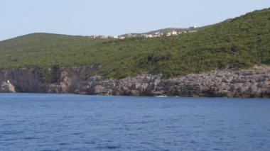 Kayalık sahil, Yeşil dağlar ve kasaba hareket 4k denizden görünüm