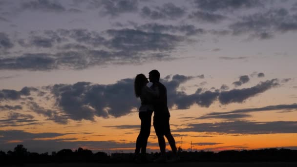 Sziluettjét romantikus pár. Férfi nő együtt a szerelmesek Kiss naplementekor — Stock videók