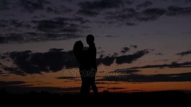 Romantik Çift karanlık siluet dans ve girdap kırmızı bir gün batımı