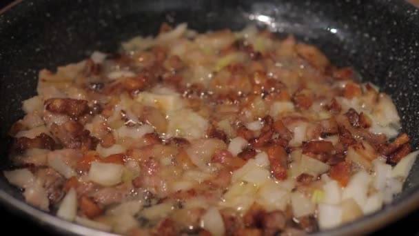 Жареный лук и бекон в сковороде, кипящее масло и жир, чтобы приготовить ужин — стоковое видео
