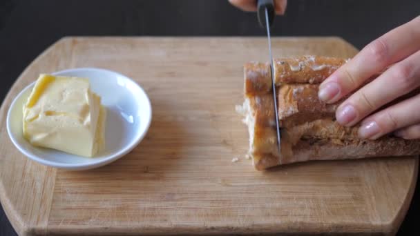 Manos cuchillo cortar pan, poner mantequilla en pieza baguette y comer 4K 3840x2160 — Vídeo de stock