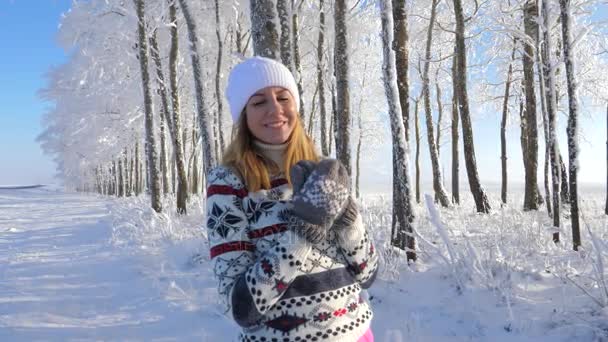 Vacker kvinna i tröja på gatan i vinter tittar och ler mot kameran. — Stockvideo