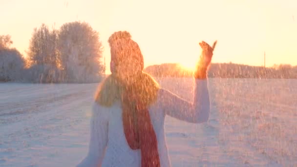 Весела жінка кидає сніг і стоїть в снігопаді танцює взимку на відкритому повітрі — стокове відео