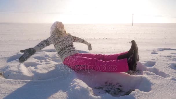 Mulher brincalhona sentada no campo de inverno, joga neve nela e queda de flocos de neve — Vídeo de Stock