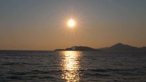 Ήλιος λάμπει στον ουρανό κάνει λαμπερά δρόμο στη θάλασσα όπου το νερό αντιθαμβωτική — Αρχείο Βίντεο