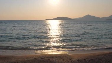 Güneş su, görünümü parlak ve parıldayan denizin üzerinde parlak yol gösteriyor. 4k