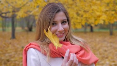 Bayan bir bej bir palto ve turuncu eşarp portresi sonbahar sarı yaprak ile çalış