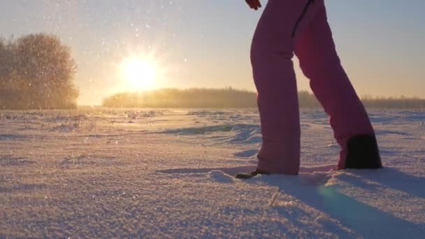 Kobieta w zimie pola o zachodzie słońca kopnął śnieg nogi rzuca płatki śniegu i mróz — Wideo stockowe