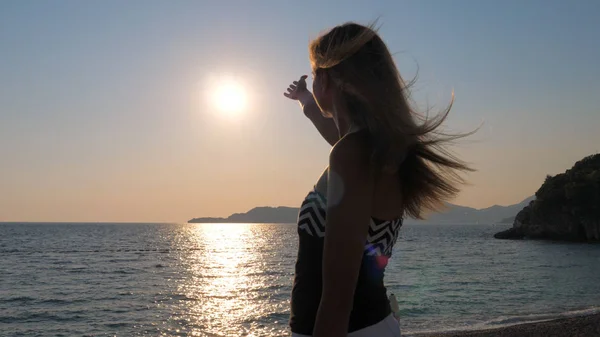 Sahil deniz üzerinde duran gökyüzünde güneş zevk eller yakalamak