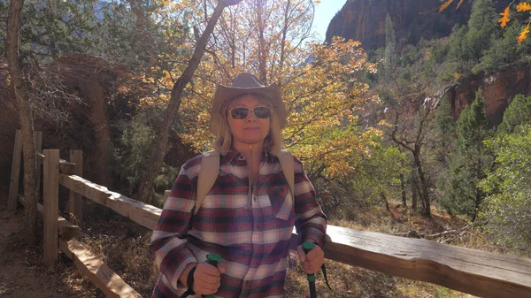 Kadın turist çitin arkasına adamlar ayakta Trekking Polonyalılar ile portresi