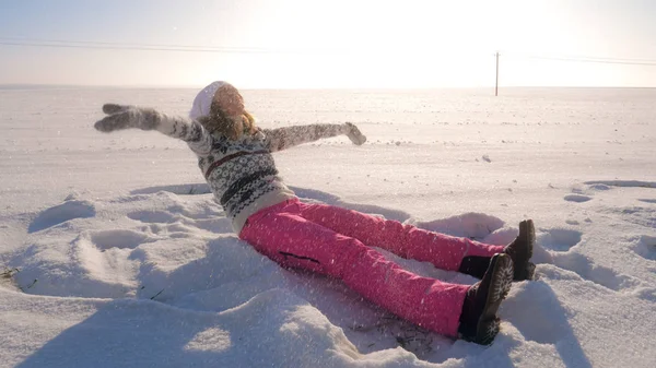 Alan kışın oturan oynak kadın onu ve düşen kar taneleri kar atar