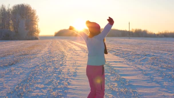 Lustige Frau bei Sonnenuntergang hebt die Arme und dreht sich in der Sonne in Zeitlupe 4k — Stockvideo