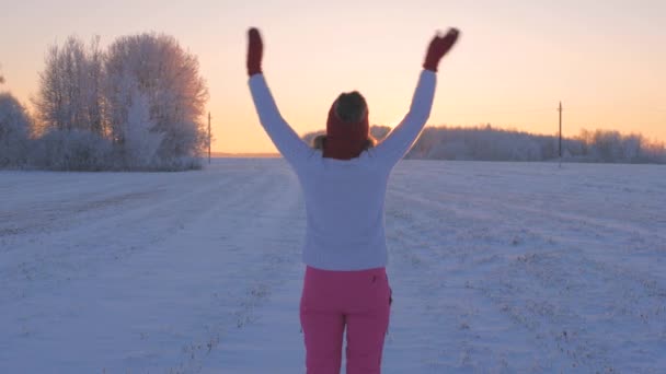 Женщина смотрит закат размахивая рукой, говоря до свидания солнце и день медленное движение 4K — стоковое видео