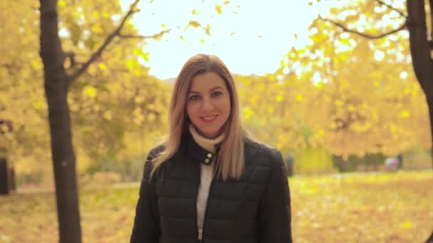 Bewegung der fröhlich lächelnden schönen jungen Frau genießt Spaziergänge im herbstlichen Park — Stockvideo