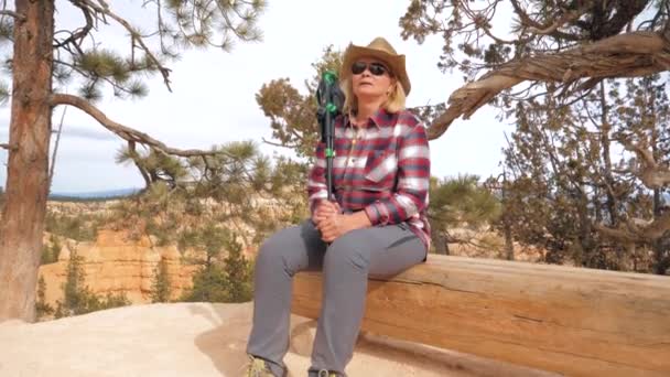 Turista mujer en el cañón Descansando sentada en un banco de madera en una ruta de senderismo 4K — Vídeo de stock