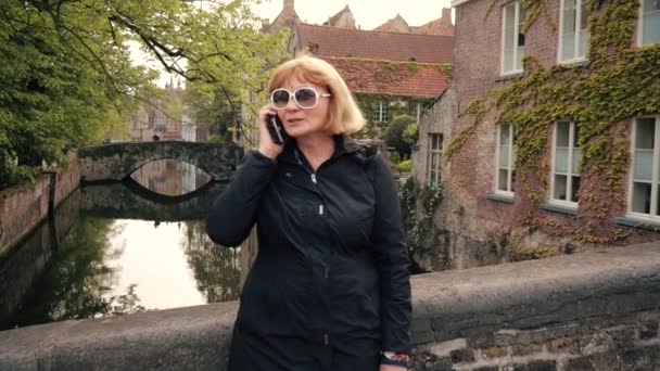 Зрілі жінки підприємець говорити по телефону на вулиці в руслі річки — стокове відео