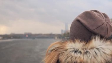 Şapkasını ve ceket kürk ile Arkadan Görünüm kadında şehir nehirde tur teknede yüzen