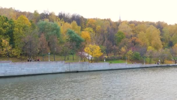 Вид на парусные лодки на каменной набережной с красочными деревьями в осеннем парке — стоковое видео