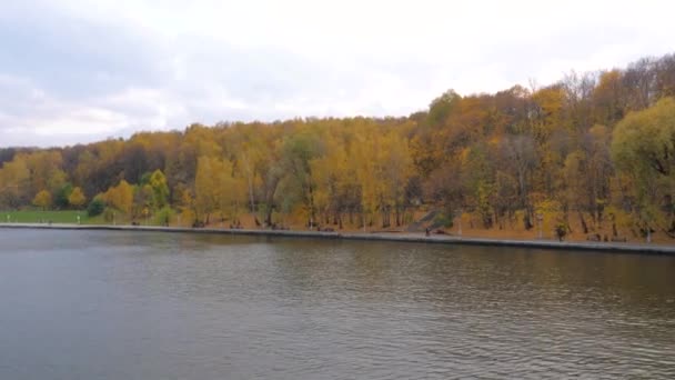 Uitzicht vanaf de boot drijvend op de rivier, steen Promenade met kleurrijke herfst Park — Stockvideo